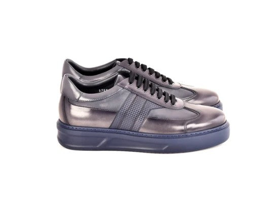 A pair of metallic silver low-top sneakers with black laces and a dark navy sole, shown from a side profile view on a white background.