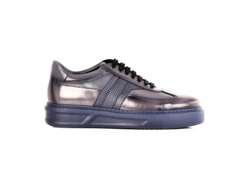A sneaker in metallic dark gray leather with black laces and a thick navy blue sole, shown from a side profile on a white background.