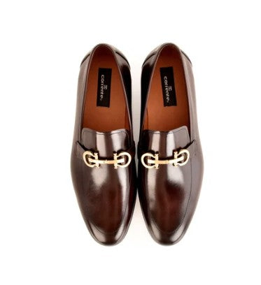 A pair of dark brown leather loafers with a silver horsebit detail shown from a top-down view on a white background. The brand name 'Corrente' is visible on the insole.