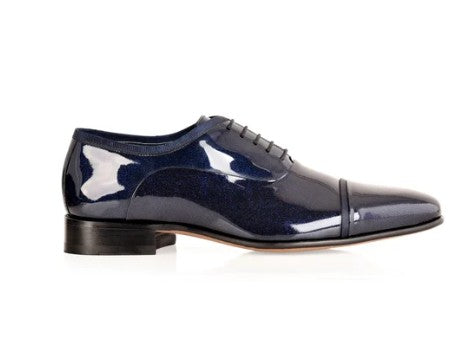 Black platform shoe with glossy finish on a white background