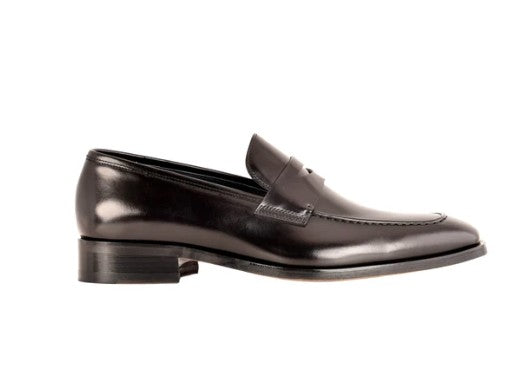 A black leather penny loafer with a low stacked heel, shown in a side profile view against a plain white background.