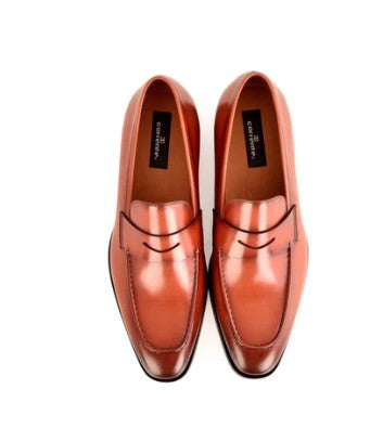 A pair of glossy tan leather penny loafers with black trim, shown from a top-down view on a white background.
