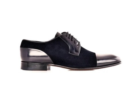A black suede and patent leather oxford shoe with a cap toe and laces, shown in a side profile on a white background.