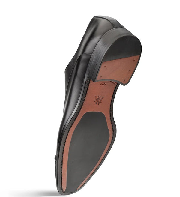 A single men's dress shoe shown from the sole side, featuring a black leather upper and toe cap with a contrasting brown insole and outsole.