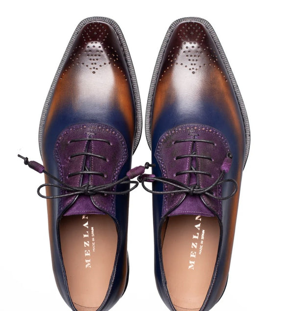 A pair of Mezlan men's oxford shoes shown from a top-down view. The shoes feature a rich color story with a deep purple leather vamp and collar and a smooth brown leather toe.