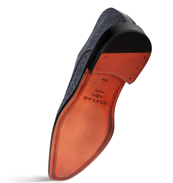 A single men's dress shoe shown from the sole side, featuring a warm orange-brown leather sole with black outsole detailing, on a white background.