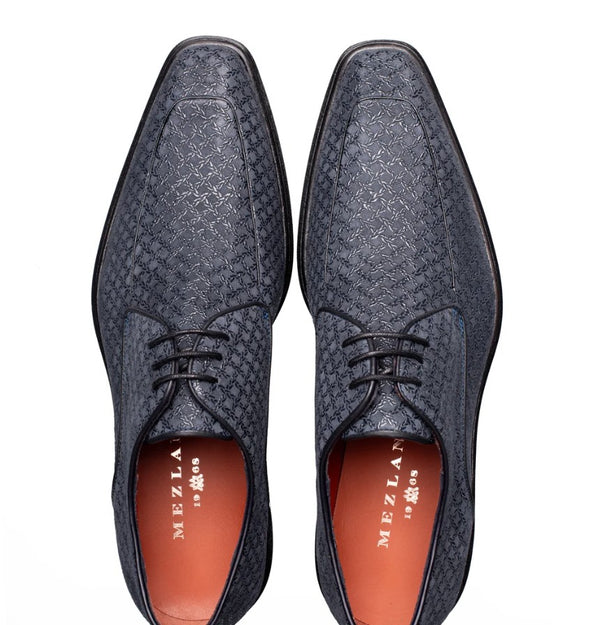 A pair of dark blue textured leather dress shoes with black laces, shown from a top-down view on a white background. The brand name 'MEZLAN' is visible on the orange inner sole.