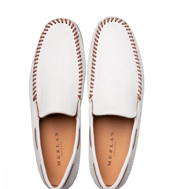 A pair of white leather moccasin-style slip-on shoes with brown contrast stitching and tan insoles, shown from a top-down view on a white background. The brand name 'MEZLAN' is printed on the insole.