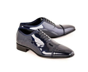 A pair of men's patent leather oxford shoes in a dark navy blue color, featuring a classic cap toe and black laces, displayed on a clean white background.