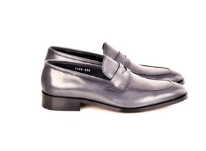 A pair of men's penny loafers in a dark gray leather, shown from a side profile view against a plain white background.