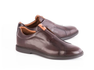 A pair of men's dark brown leather slip-on shoes with a small tan leather accent tab, shown on a white background.