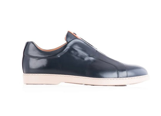 A single men's slip-on leather shoe in dark navy blue with a light beige sole, shown in a side profile against a white background.