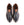 A pair of black leather slip-on dress shoes with tan accents and a black brand label visible inside, shown from a top-down view on a white background.
