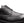 Close-up of a black leather lace-up shoe with a textured, embossed pattern on a plain white background.