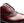 A close-up of a men's oxford shoe in glossy burgundy leather with dark brown brogue perforated detailing and black laces, shown against a plain white background.