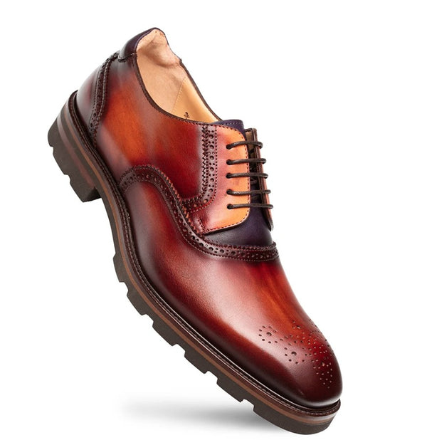 A single men's wingtip oxford shoe in glossy brown leather with brogue detailing