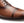 Close-up of a brown leather cap-toe oxford shoe showing the toe, side panel, laces, and stitching on a white background.