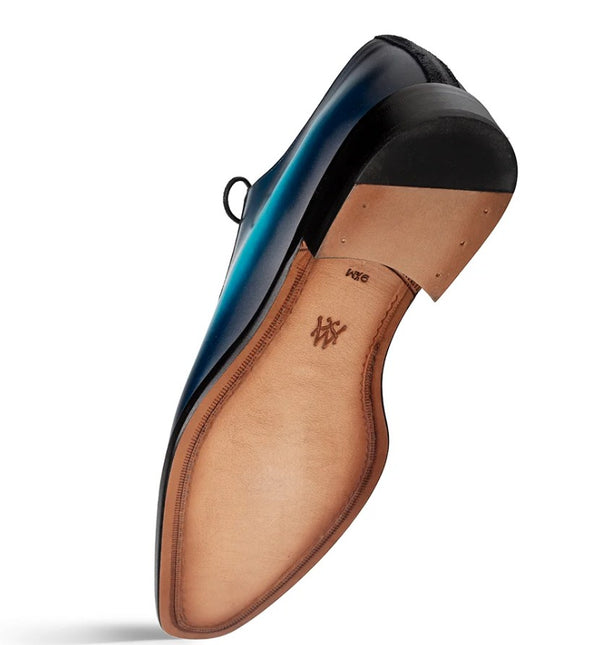 A single men's dress shoe shown from the sole angle, featuring a tan leather insole and a black outsole.