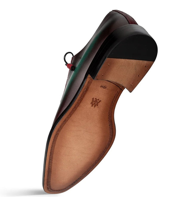 A single men's dress shoe shown from the sole side featuring a tan leather insole with an embossed monogram logo, and a black outsole, photographed on a white background.