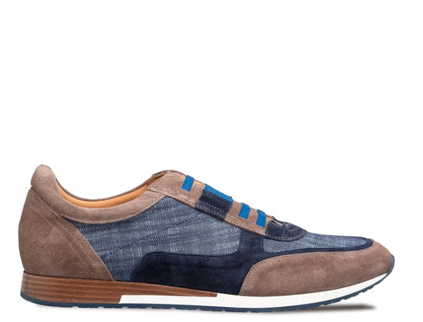 A low-top sneaker featuring a mix of brown suede, blue denim, and navy suede panels, with bright blue laces and a brown and white sole.