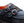 A close-up of a dark navy blue suede double strap shoe with silver buckle closures and a visible orange interior lining.