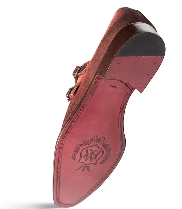 A single men's dress shoe shown from the sole sid, featuring a reddish-brown suede upper with a double strap buckle, a dark gray outsole, and a matching reddish-brown insole with an embossed logo.