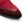 Close-up of a burgundy suede shoe toe with black sole on a white background.
