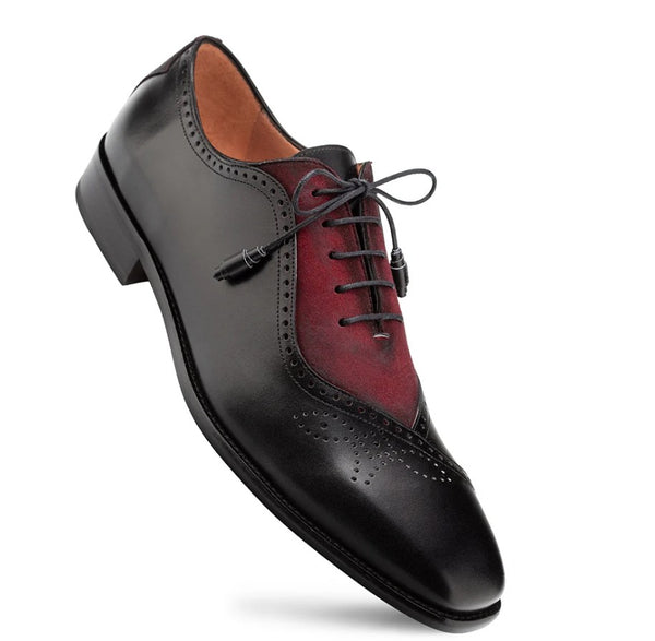 A men's wingtip oxford shoe with a black leather finish and a contrasting deep red suede panel, featuring black laces and a low stacked heel, shown on a white background.