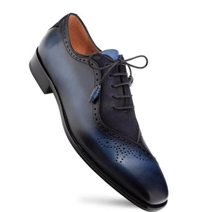 A single men's oxford wingtip shoe in dark navy blue leather, shown at an angle on a clean white background.