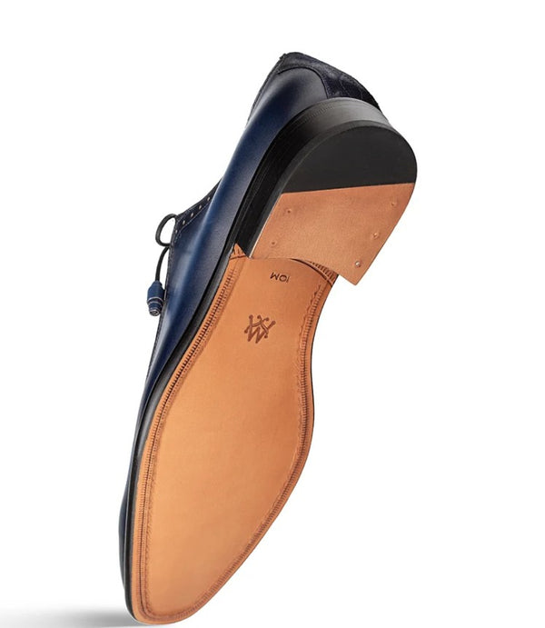 A single navy blue leather dress shoe shown from the sole side, highlighting the tan leather insole and black outsole, on a white background.