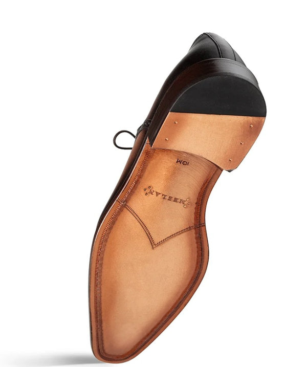 A single men's dress shoe shown from the sole side on a white background.