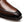 Close-up of a brown leather dress shoe toe cap showing the smooth vamp, decorative stitching, and dark brown sole edge on a white background.